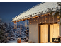 LED-Eiszapfen-Lichterkette an einem verschneiten Haus.