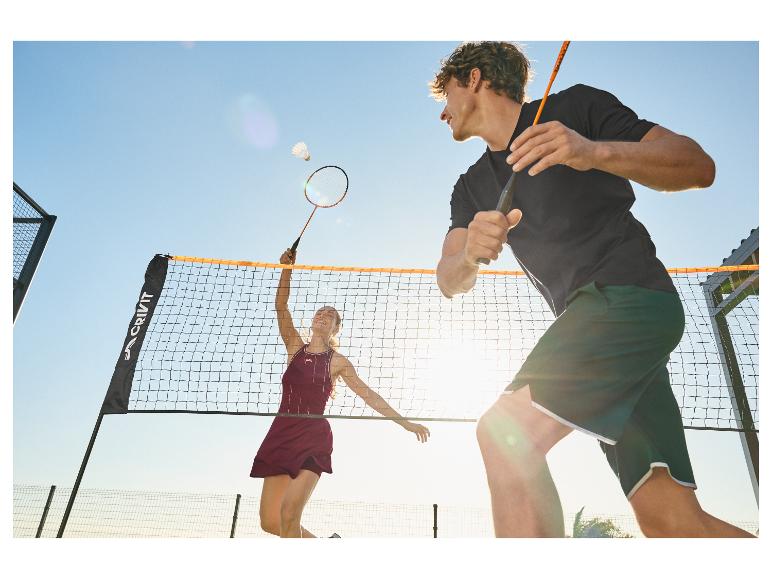 Zwei Badmintonspieler, ein Mann und eine Frau, auf einem Außenplatz.