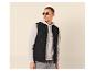 Mann in schwarzer Steppweste, grauem Hoodie und grauer Jeans.