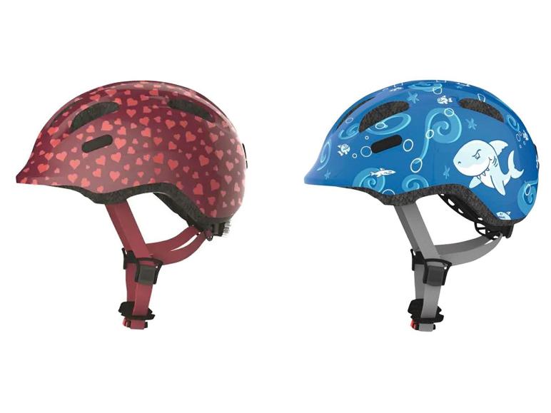 Zwei Kinderhelme, einer mit Herzchen, einer mit Haien.
