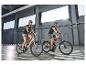 Mann und Frau auf E-Bikes in einer Tiefgarage.