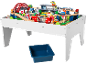 Holzeisenbahn-Set auf einem weißen Spieltisch mit einer blauen Aufbewahrungsbox darunter.