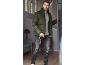 Mann in olivgrüner Pufferjacke, grauem T-Shirt und dunklen Jeans, der eine Leine hält.