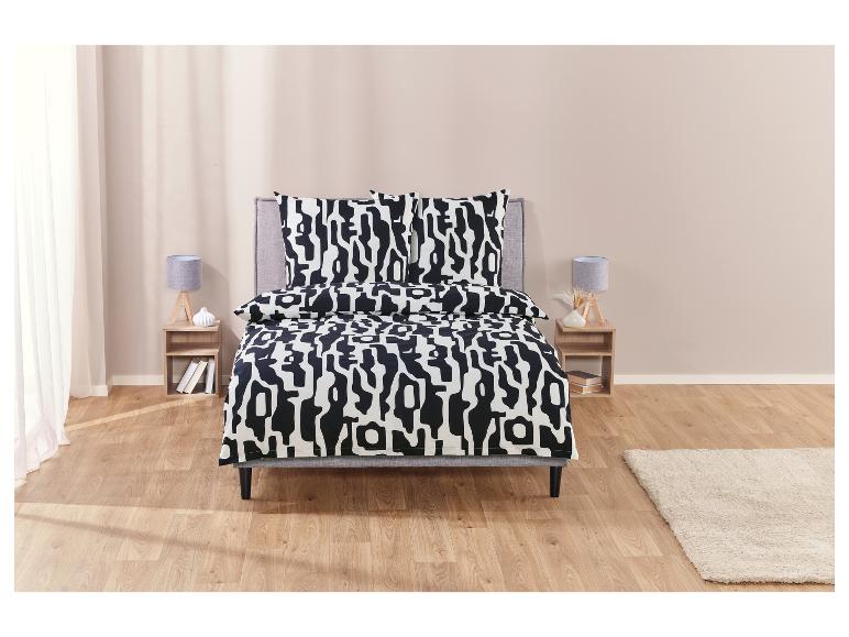 Ein Bett mit einer schwarzen und weißen Bettwäsche mit geometrischem Muster