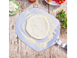 Frischer Pizzateig auf einem Pizzaschieber, mit Käse und Kirschtomaten.