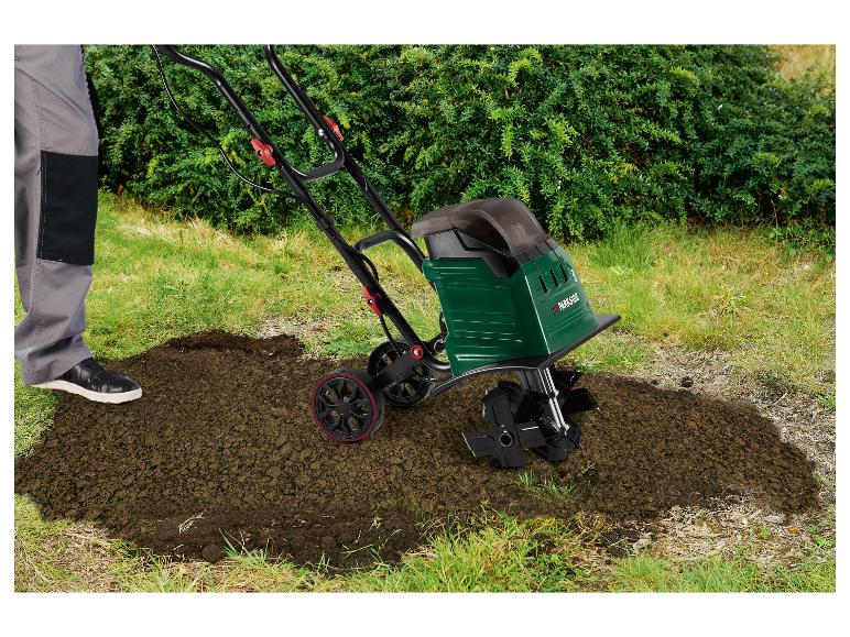 Person mit Parkside-Bodenhacke lockert Erde im Garten auf.