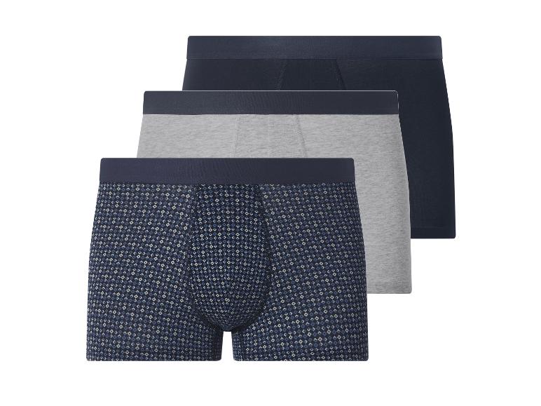 Drei Herren-Boxershorts: eine gemusterte, eine graue und eine dunkelblaue.