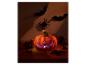 Halloween-Kürbis mit leuchtendem Gesicht, umgeben von Herbstdekorationen und gruseligen Fledermäusen.