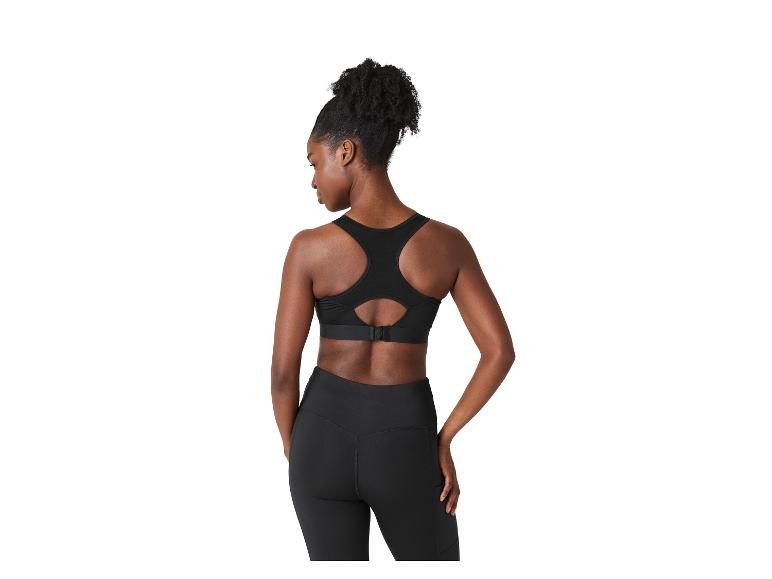 Frau von hinten in schwarzem Sport-BH und Leggings.