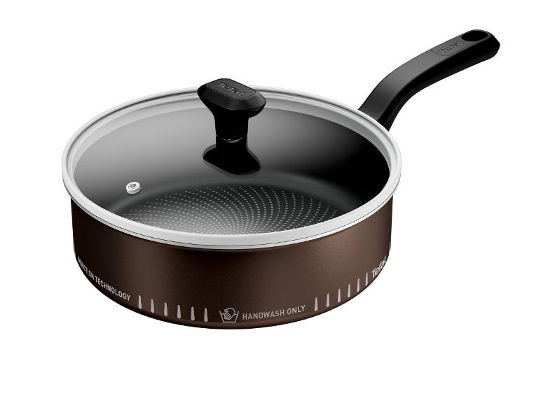 Braune Pfanne mit Glasdeckel und schwarzem Griff, mit der Aufschrift „HANDWASH ONLY“.