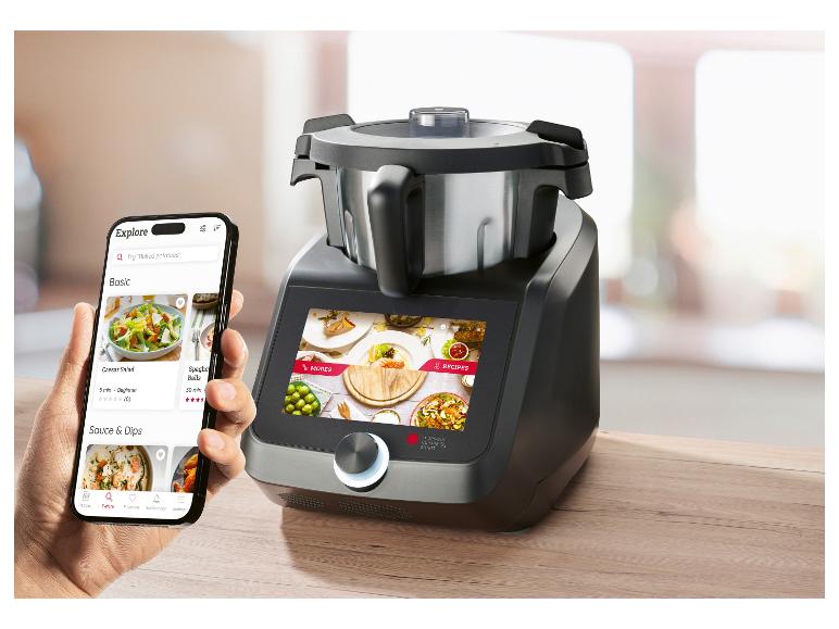 Smartphone mit Rezept-App neben einer intelligenten Küchenmaschine.