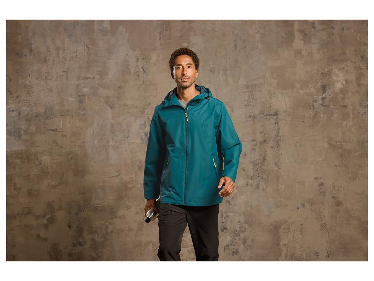 Mann in einer blauen Jacke mit Kapuze und schwarzen Hosen