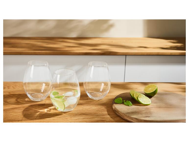 Drei Gläser mit Limette, Minze und Eis auf einem Holztisch.
