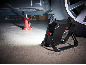 Tragbarer LED-Arbeitsstrahler beleuchtet einen Wagenheber in einer Garage.