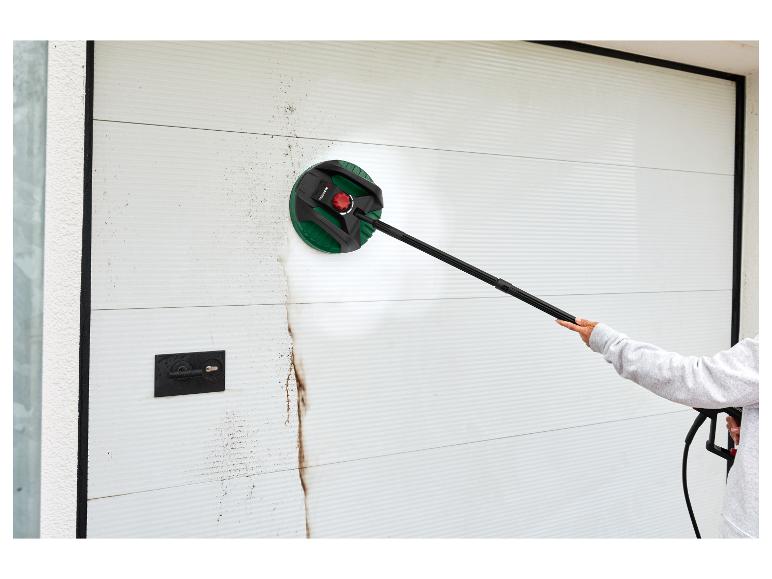 Person reinigt ein schmutziges weißes Garagentor mit einem Parkside Flächenreiniger.