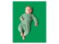 Baby liegt auf grünem Untergrund in einem grünen Strampler mit Dinosaurier-Motiv.
