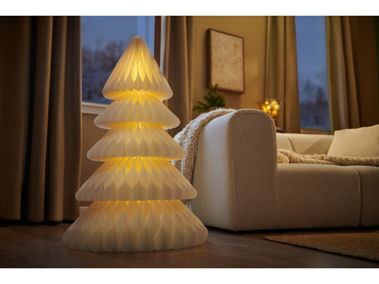 Dekorative Stehlampe in Form eines leuchtenden Weihnachtsbaums in einem gemütlichen Wohnzimmer.