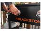 Person, die die Bedienelemente eines schwarzen Outdoor-Grills mit orangefarbener Schrift einstellt.