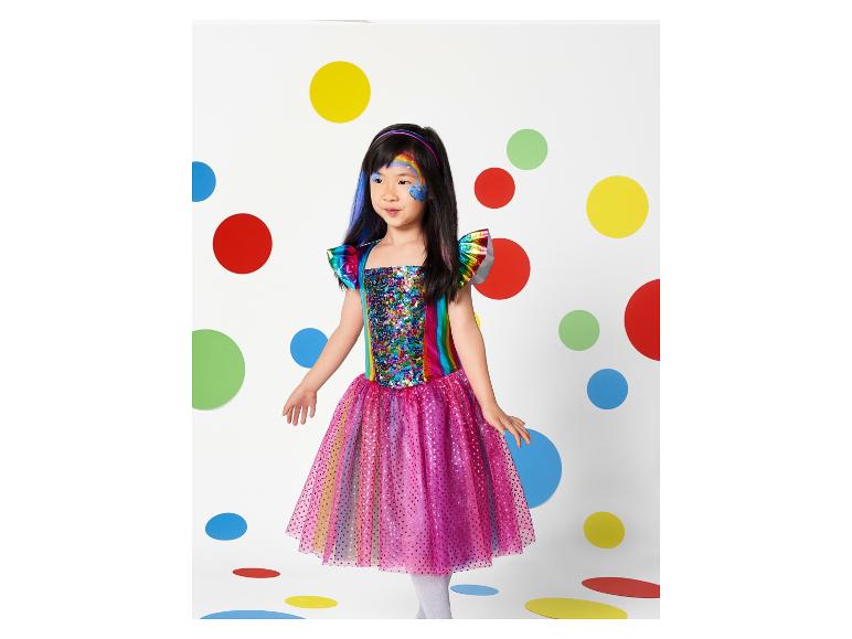 Ein Mädchen trägt ein regenbogenfarbenes Kleid mit Pailletten und einem rosa Tüllrock.