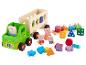 Ein grüner Spielzeug-LKW mit Peppa Pig Figuren und bunten Blöcken.
