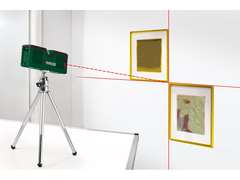 Laserwasserwaage auf Stativ, die rote Linien auf eine Wand mit zwei Bildern projiziert.