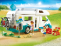 Kinder-Spielset mit Wohnmobil, Spielfiguren und Zubehör auf einem Campingplatz am Meer.