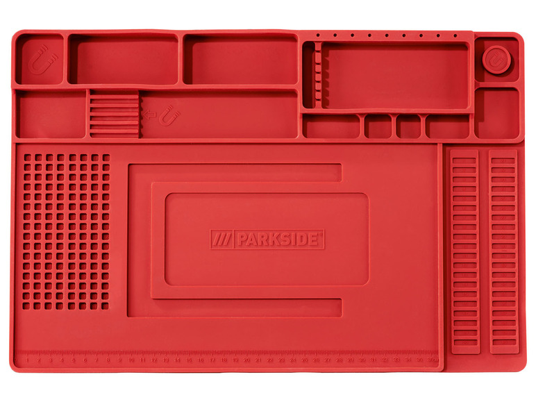 Eine rote Parkside Arbeitsmatte mit verschiedenen Fächern und einem Lineal.