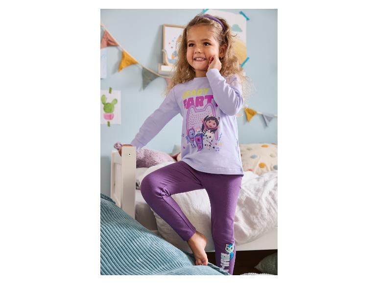 Mädchen in lila Pyjama mit „Ready to Party“-Aufdruck und Zeichentrickfiguren.