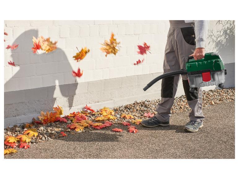 Mann benutzt einen Laubbläser, um Herbstlaub von einem Weg zu entfernen.