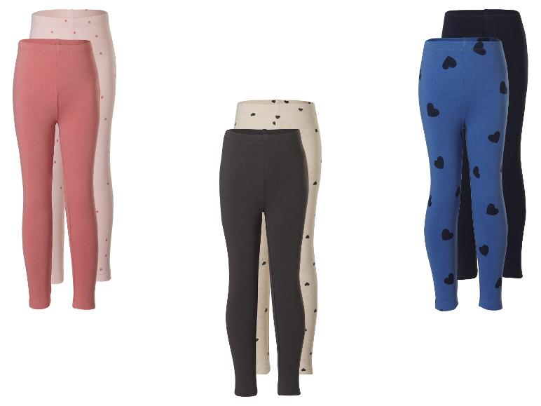 Drei Paar Kinderleggings: rosa gepunktet, beige mit Herzen und blau mit Herzen.