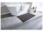 Eine Badewanne mit einer geometrischen Badmatte.