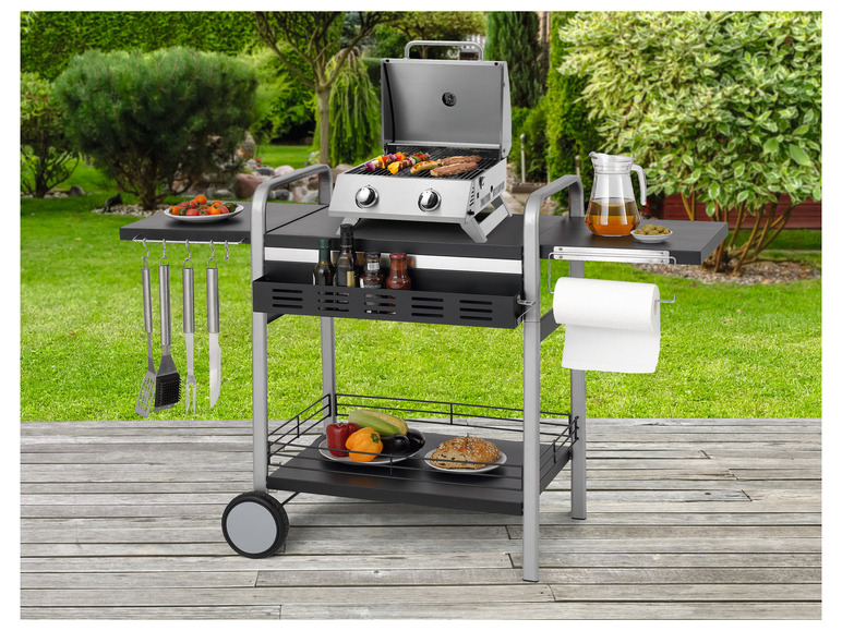 Ein Gasgrill mit dazugehörigem Wagen und Zubehör.