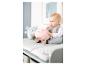 Baby sitzt auf einem Wickeltisch mit Plüschtieren, einem rosa und einem blauen.