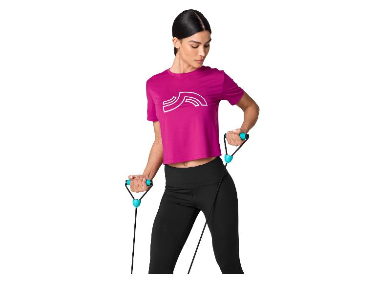 Frau in fuchsiafarbenem Shirt und schwarzen Leggings trainiert mit Widerstandsband.