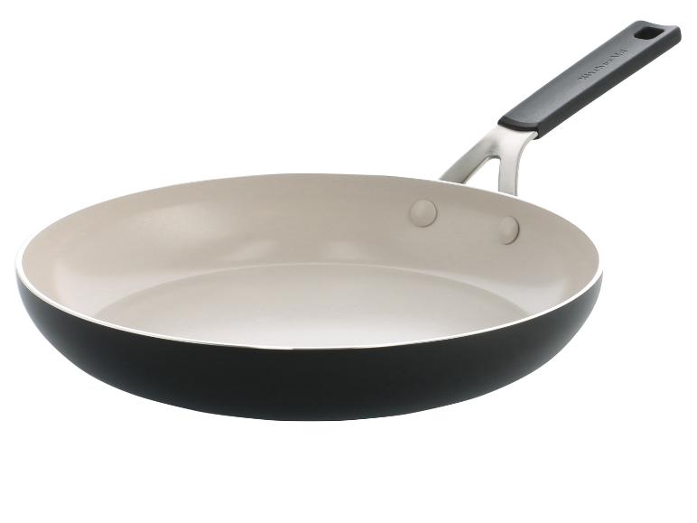 Eine KitchenAid Bratpfanne mit cremefarbener Innenseite und schwarzer Außenseite, mit Metall- und schwarzem Griff.
