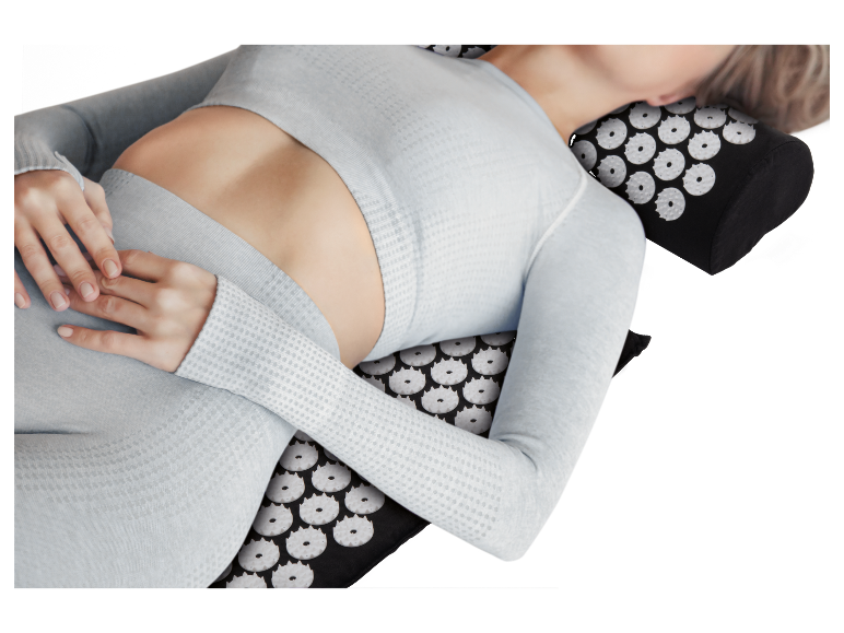 Frau entspannt sich auf einer Akupressurmatte.