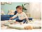 Baby sitzt auf einer Spielmatte und trägt einen LUPILU® Langarmbody.