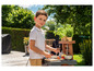 Ein Junge spielt mit einem Spielzeuggrill und Küchenutensilien.