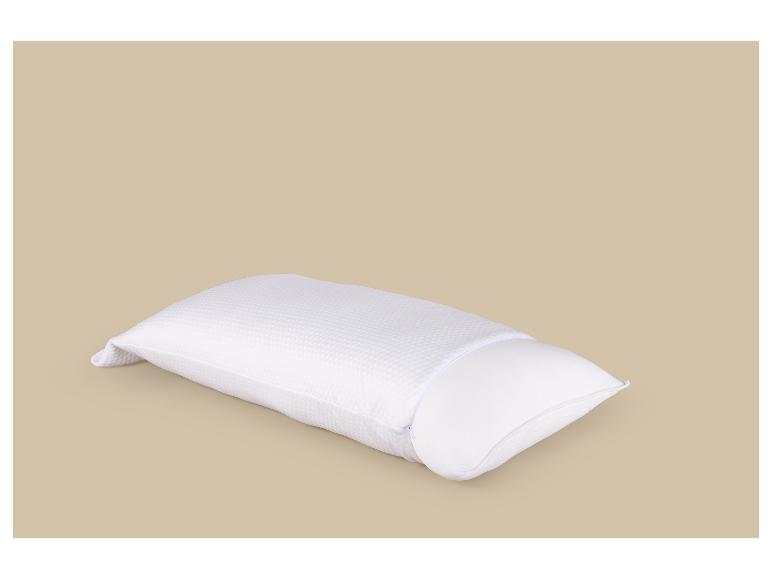 Weißes Kissen mit Schutzbezug auf beigem Hintergrund.