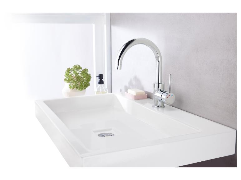 Ein weißes Waschbecken mit einem verchromten Wasserhahn