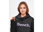 Frau in einem schwarzen Bench Hoodie.