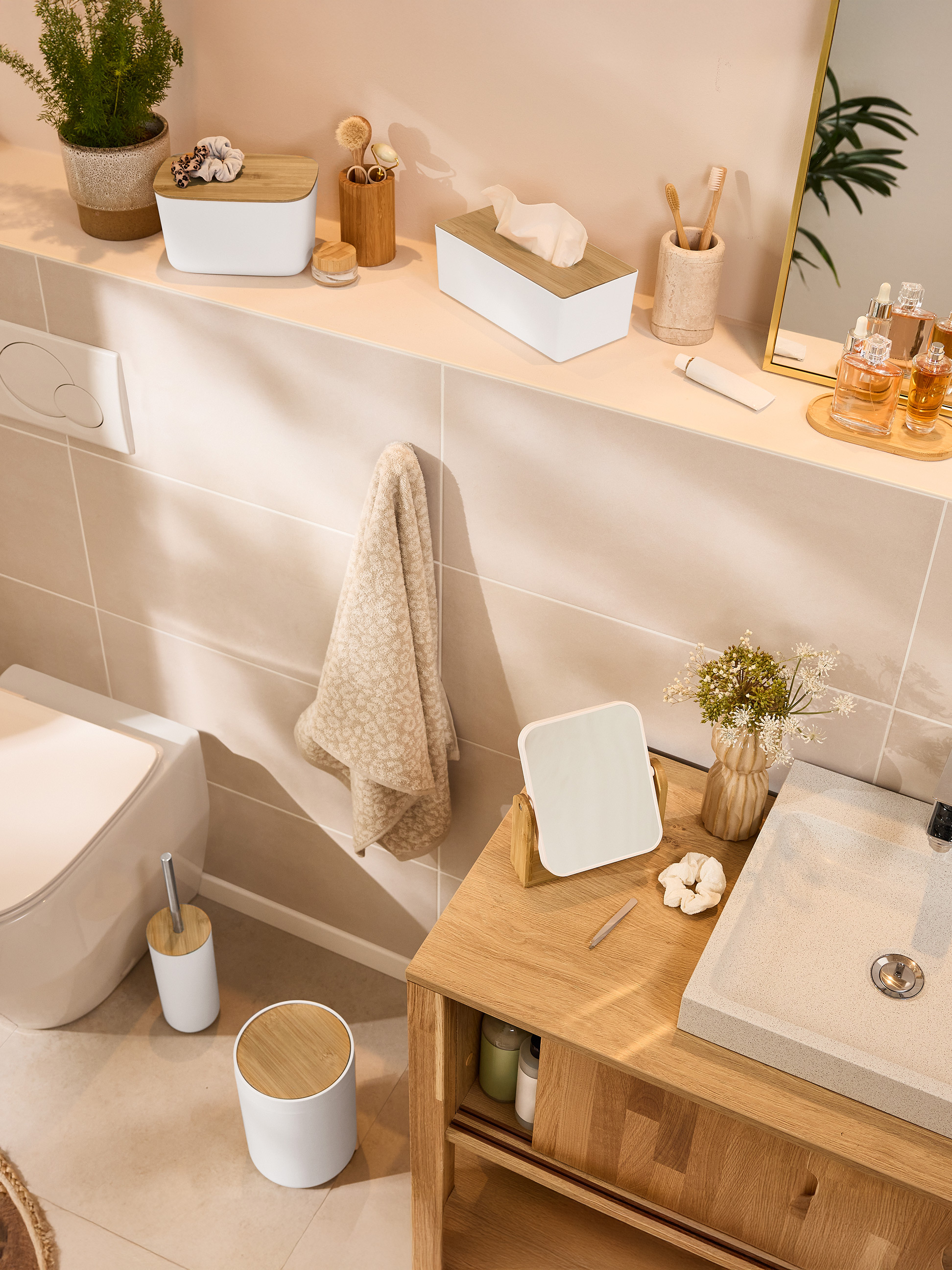 Badezimmer mit Bambus-Accessoires, Toilette und Waschbecken.