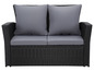 Schwarze Wicker-Couch mit grauen Kissen.