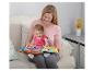 Mutter und Baby sitzen auf einem Sofa, Baby spielt mit einem interaktiven Buch.