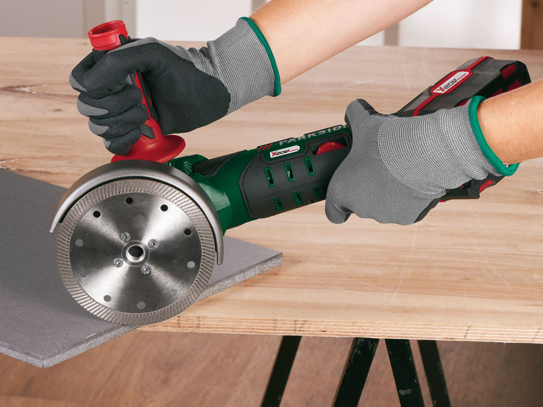 Eine Person verwendet eine Parkside Akku-Winkelschleifer mit Diamanttrennscheibe zum Schneiden von Fliesen.