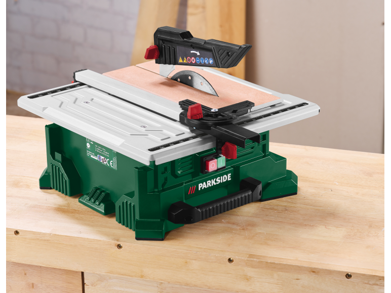 Eine grüne und weiße Tischkreissäge mit Kreissägeblatt auf einer Holzwerkbank.