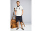 Mann trägt ein weißes Poloshirt mit blauen Details und schwarze Cargo-Shorts.