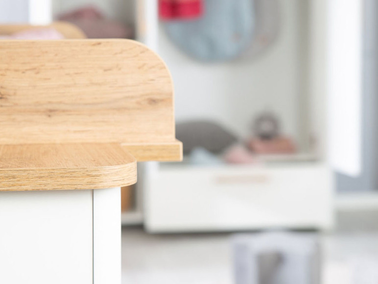 Eine Holzplatte auf einer weißen Kommode.