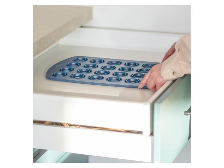 Eine blaue Backform mit 24 Vertiefungen in einem Küchenschrank