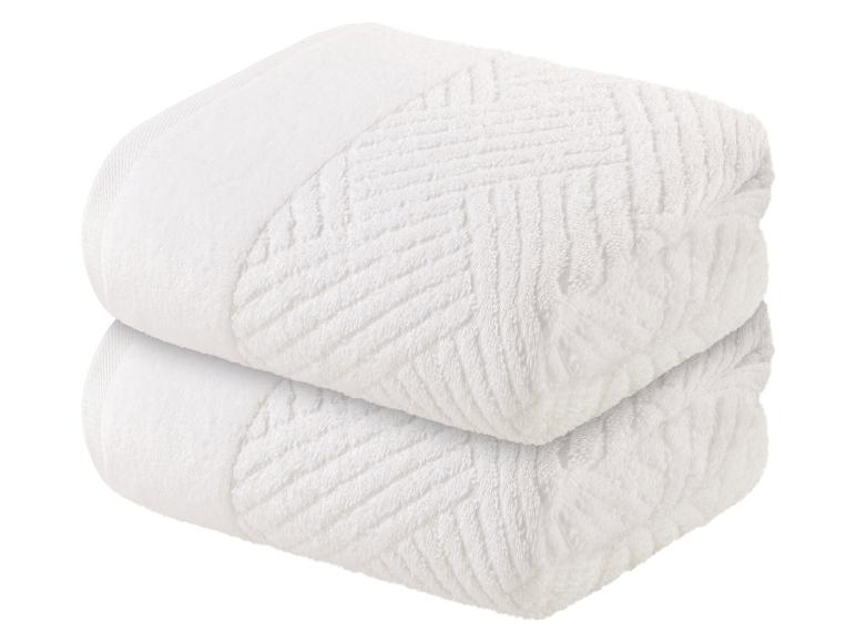 Zwei weiße Handtücher mit Zickzackmuster.